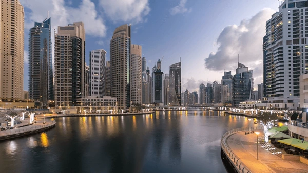 Dubai Marina skyline at dusk showing iconic residential towers reflected in the canal and Marina Walk promenade 2026