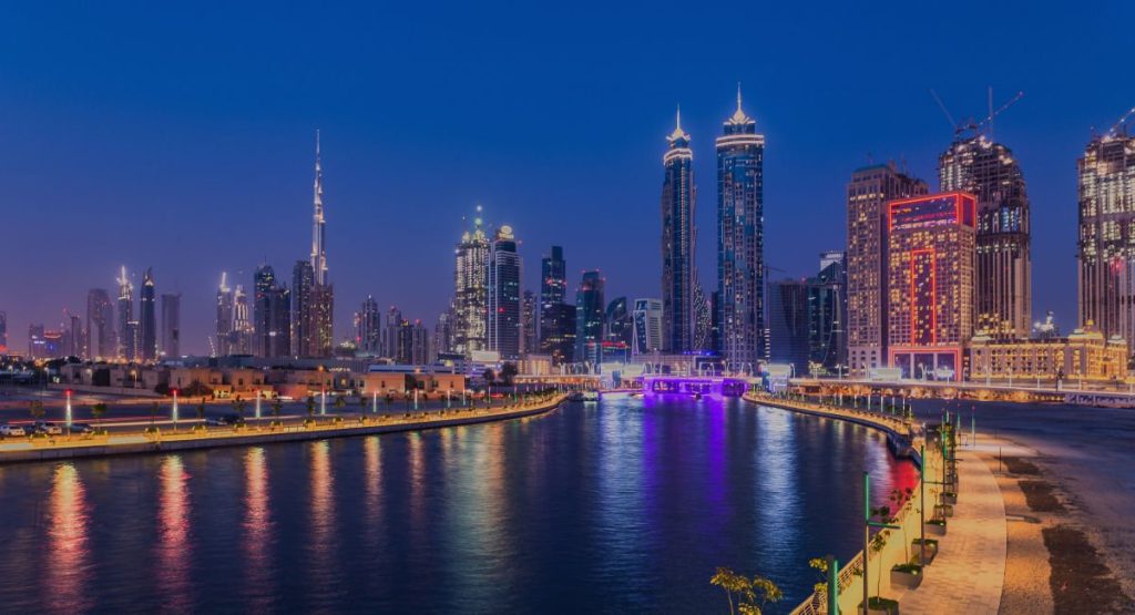 Business Bay Dubai Canal waterfront promenade with restaurants and Burj Khalifa view at dusk